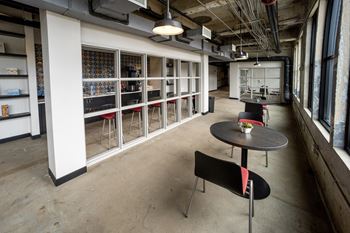 a room with tables and stools in front of a window